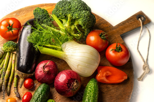 Exposition of fresh organic vegetables on wooden plate. tomato, pepper, broccoli, onion, garlic, cucumber,  eggplant, black Eyed Peas, ecological bag.