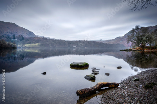 A still and misty morning shot of the shoreside at Lake Buttermere in the lake District National Park. .
