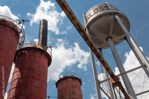 Sloss Furnaces National Historic Landmark, Birmingham Alabama USA, view looking up at water tower and furnaces against a blue sky with clouds, horizontal aspect