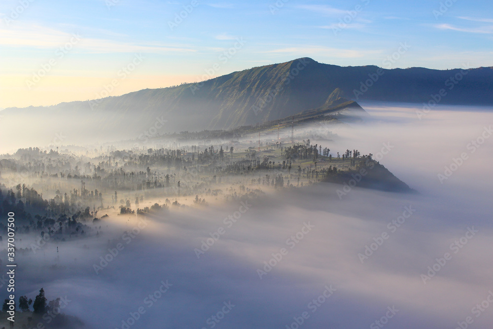 Sunlight at Cemoro Lawang village covered by volcanic fog at Mount Bromo, East Java, Indonesia