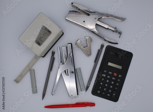 Différents outils de bureau, calculatrice, agrafeuses, perforateur, stylo photo