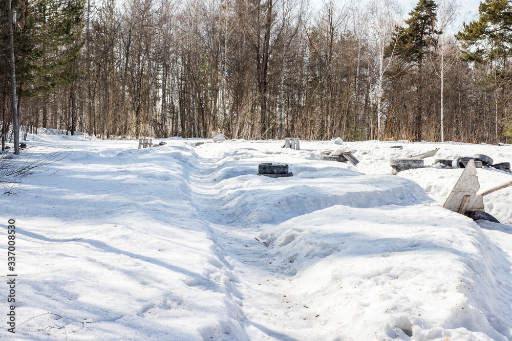 Old tires from cars and trees. Paintball territory in the forest. Background for advertising Old tires from cars and trees. Paintball territory in the forest. Background for advertising