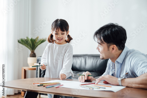 Father and daughter at home painting