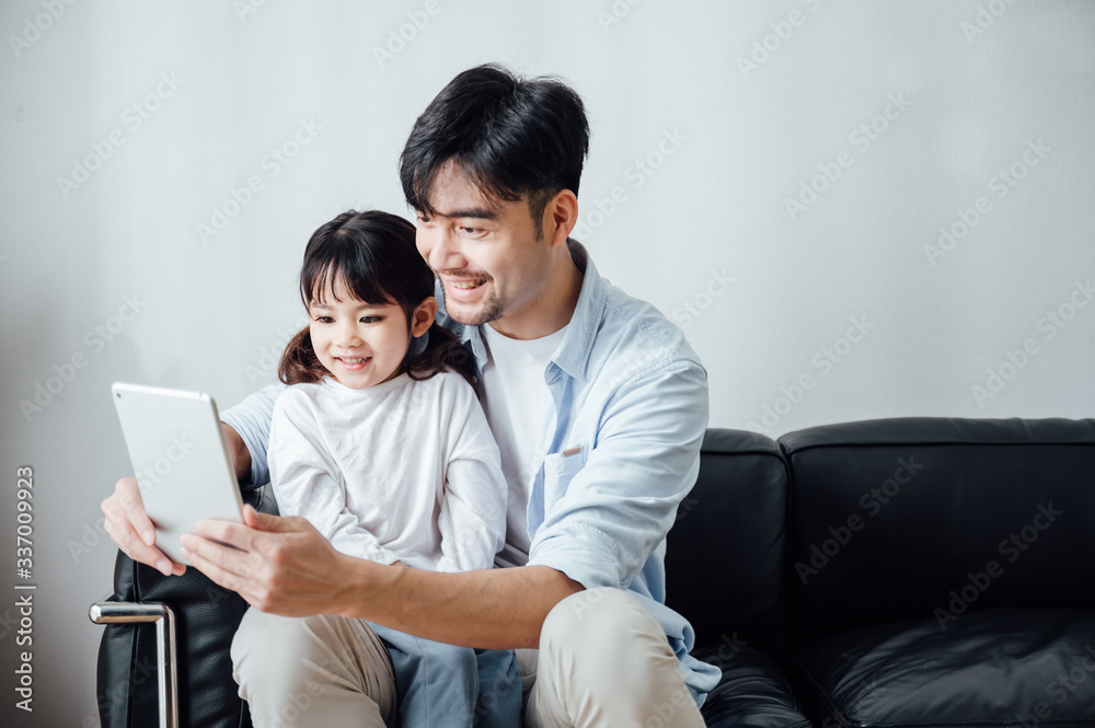Father and daughter at home using a Tablet PC Father and daughter at home using a Tablet PC