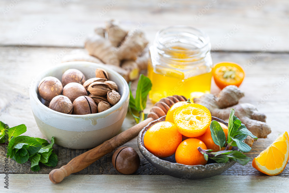 Obraz premium set of products to boost the immune system. Honey, lemon, nuts, ginger to Immunity boosting.