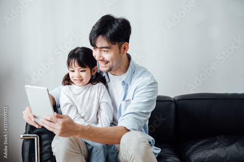 Father and daughter at home using a Tablet PC