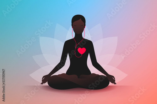 Woman is sitting in lotus position and listening music of her heart
