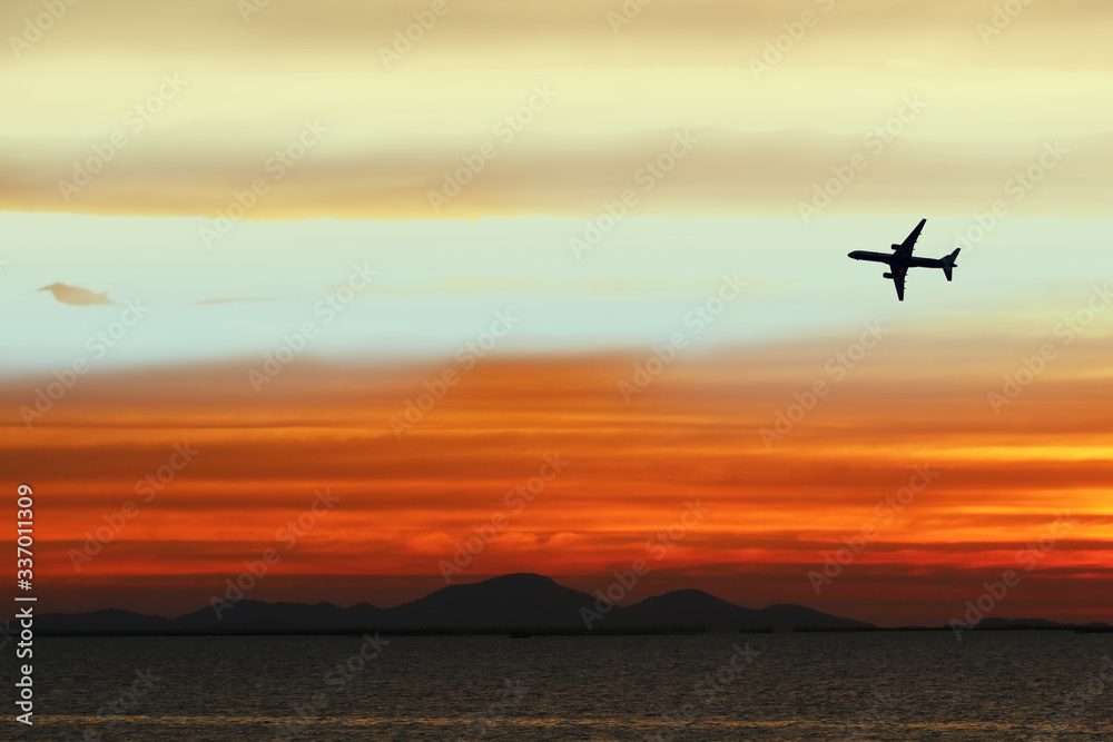 silhouette airplane on sky in sunset back on cloud white orange yellow red color