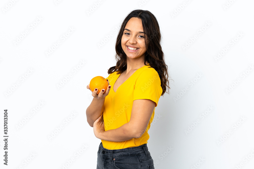 Young woman over isolated white background holding an orange Young woman over isolated white background holding an orange
