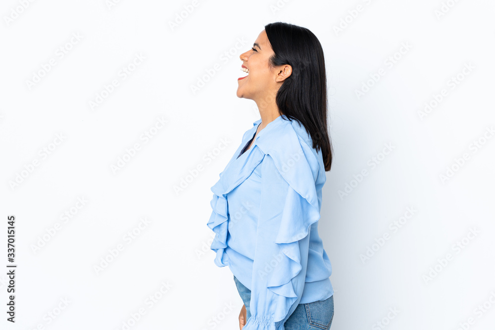 Young latin woman woman isolated on white background laughing in lateral position Young latin woman woman isolated on white background laughing in lateral position