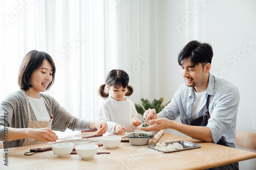 Mom and Dad and daughter at home dumplings