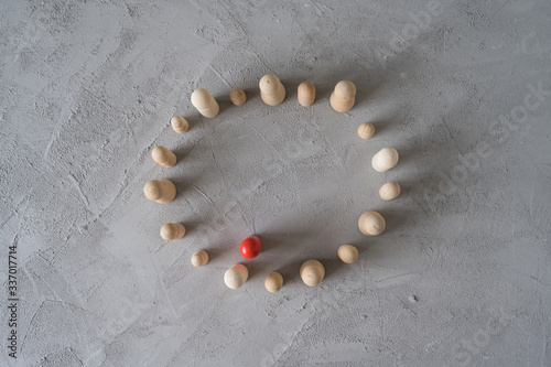 Foto Virus infected red wooden man communicate with people stand in a vicious circle on a gray background