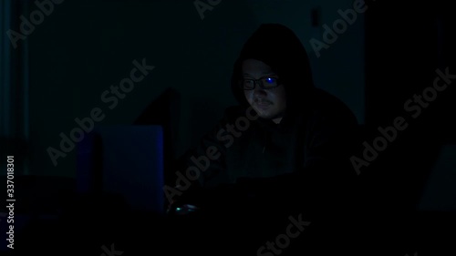 A computer programmer or hacker prints a code on a laptop keyboard to break into a secret organization system.