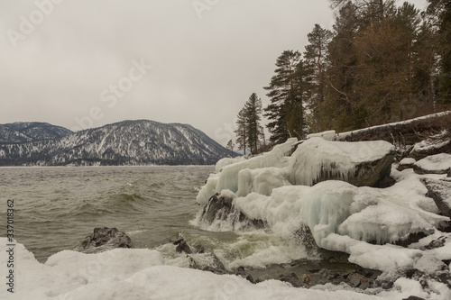 Shoreline of Teletskoye lake with thundering waves  in winter. Russia  Altai territory