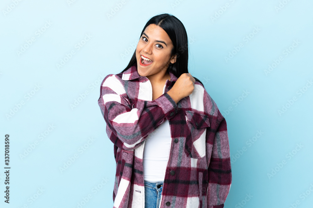 Young latin woman woman isolated on blue background celebrating a victory Young latin woman woman isolated on blue background celebrating a victory