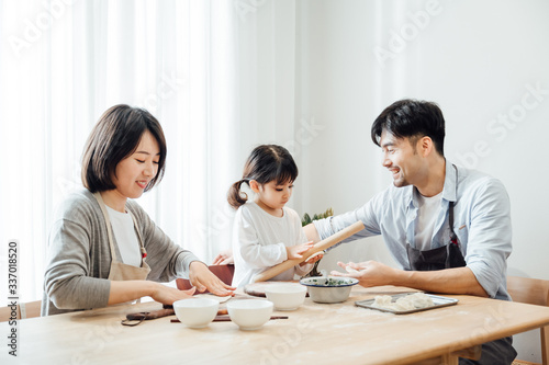 Mom and Dad and daughter at home dumplings