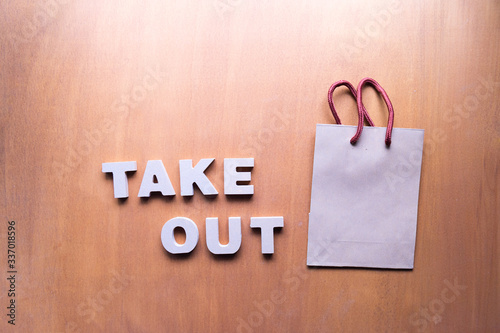 take out service concept ,take away text and Paper bag on wooden background