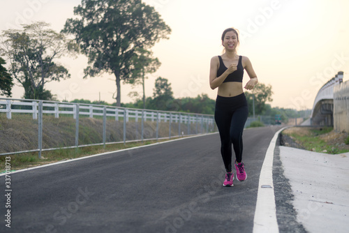 Asian woman exercising before exercising on public roads. She is running.