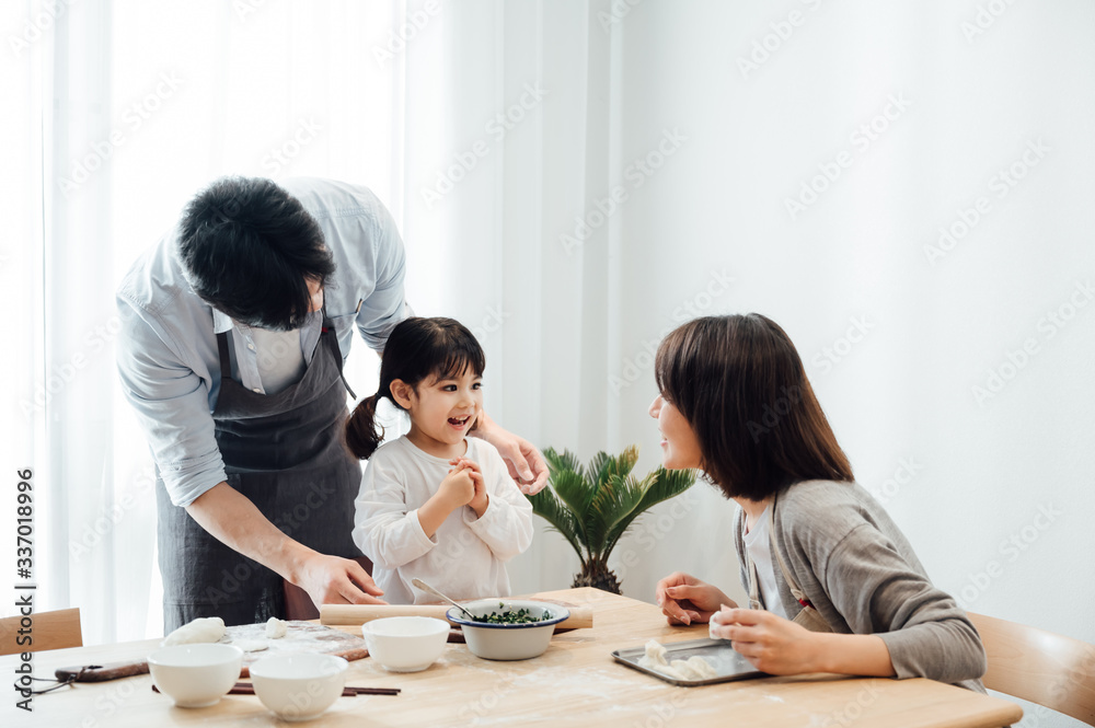 Fototapeta premium Mom and Dad and daughter at home dumplings