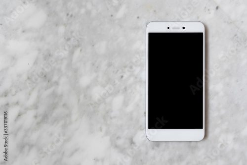 Flat lay of a white smartphone in a marble background, black and white, recepcionist job photo