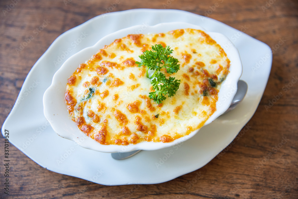 Baked Spinach with Cheese on white plate Baked Spinach with Cheese on white plate