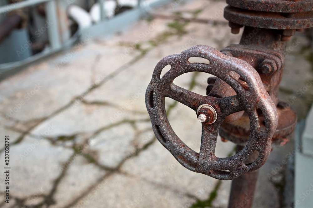Industrial pipeline and valve close up, blur concrete background. Old rusty control equipment, abandoned plant industry with copyspace Industrial pipeline and valve close up, blur concrete background. Old rusty control equipment, abandoned plant industry with copyspace
