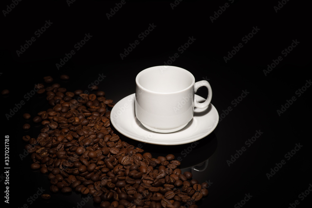 Obraz premium Cup with coffee beans on a dark background