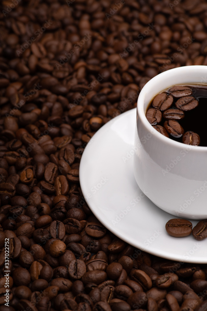 Fototapeta premium Cup with coffee beans on a dark background