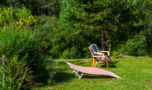 Two chairs in lush green nature garden. Beautiful backyard garden and patio area. © eskstock
