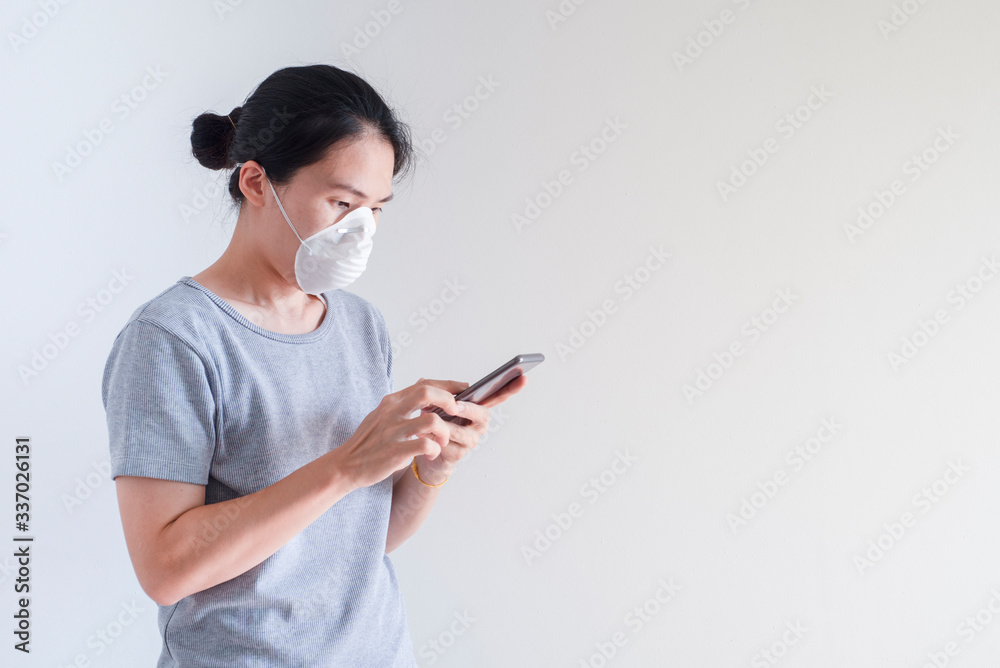 Asian young woman using smart phone wearing face mask protect air pollution, particulates and for protection flu.Coronavirus (COVID-19) outbreak prevention. Health care concept Asian young woman using smart phone wearing face mask protect air pollution, particulates and for protection flu.Coronavirus (COVID-19) outbreak prevention. Health care concept