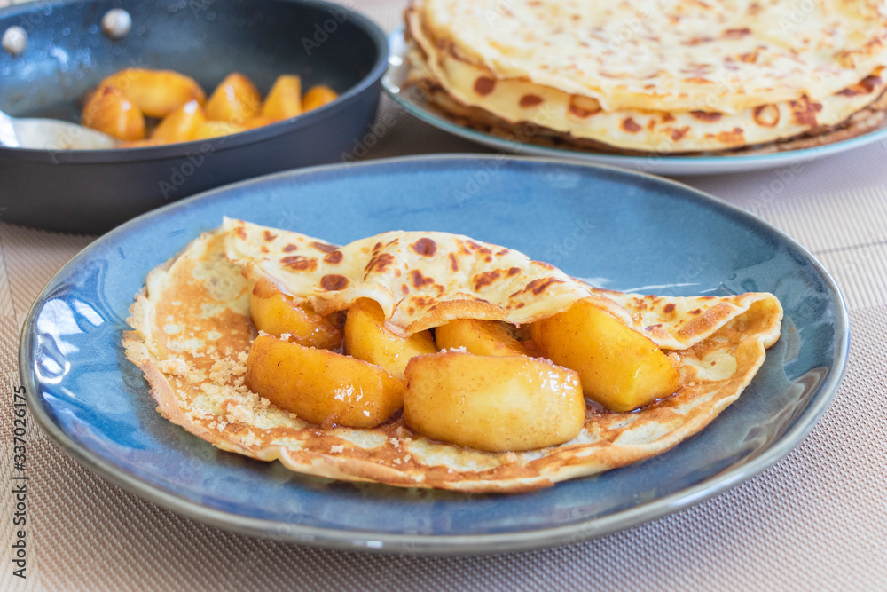 image of crepe cake with apple served with sirop and sugar powder. image of crepe cake with apple served with sirop and sugar powder.