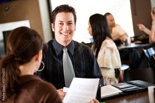 Coffee: Cheerful Businessman Looking At Documents with Co-worker