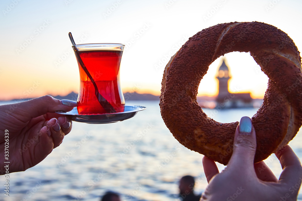 A cup (armud) of traditional Turkish tea and Simitci in hand on the ...