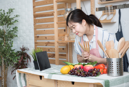 Happy asian woman looking recipe tablet kitchen reading cooking at home,University colleague student study online with social media,Social distancing, stay at home and work from home concept.