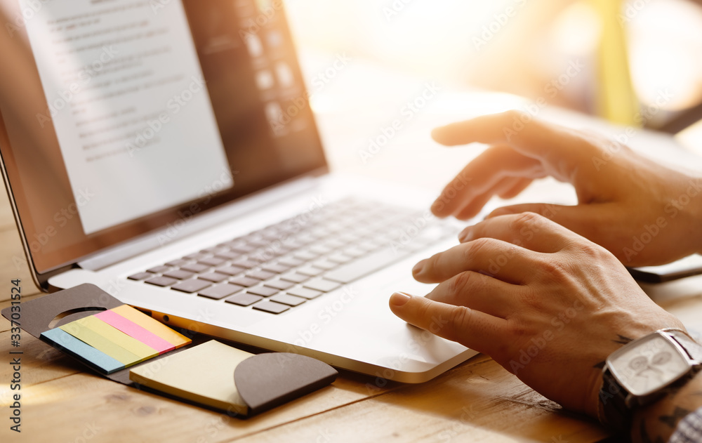 Close-up photo of male hands with laptop. Man is working remotely at home Close-up photo of male hands with laptop. Man is working remotely at home