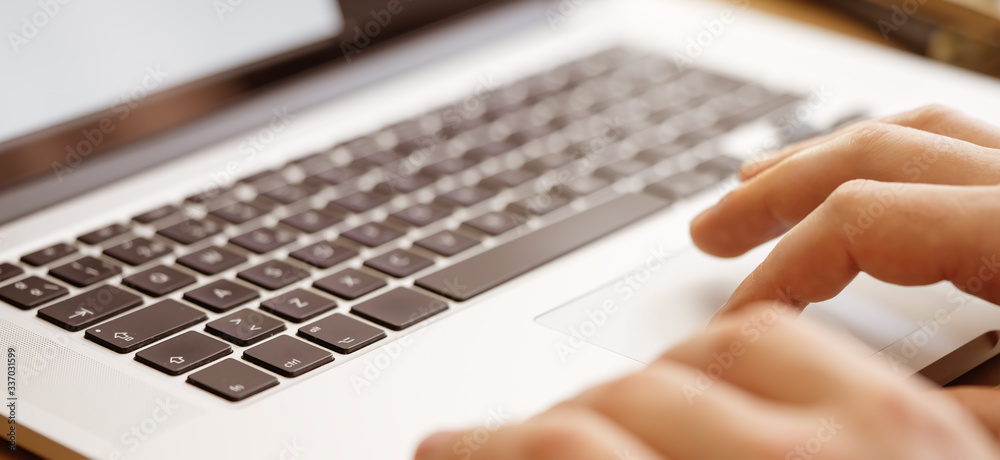 Close-up photo of male hands with laptop. Man is working remotely at home Close-up photo of male hands with laptop. Man is working remotely at home