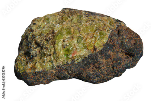 Quadro su tela Olivine gemstone included in black lava basalt rock isolated on white background