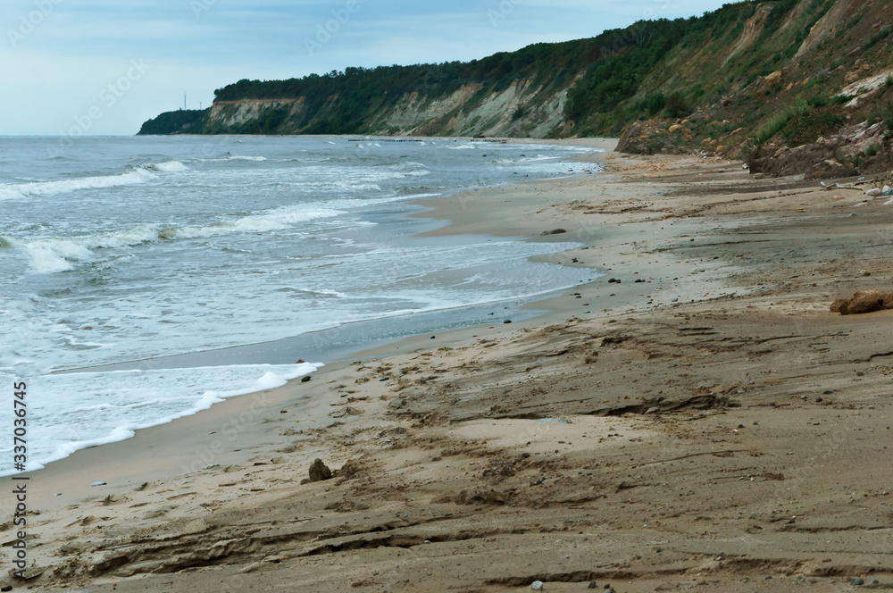 Steep coast of the sea. Landslides and destruction to the shores of the sea.