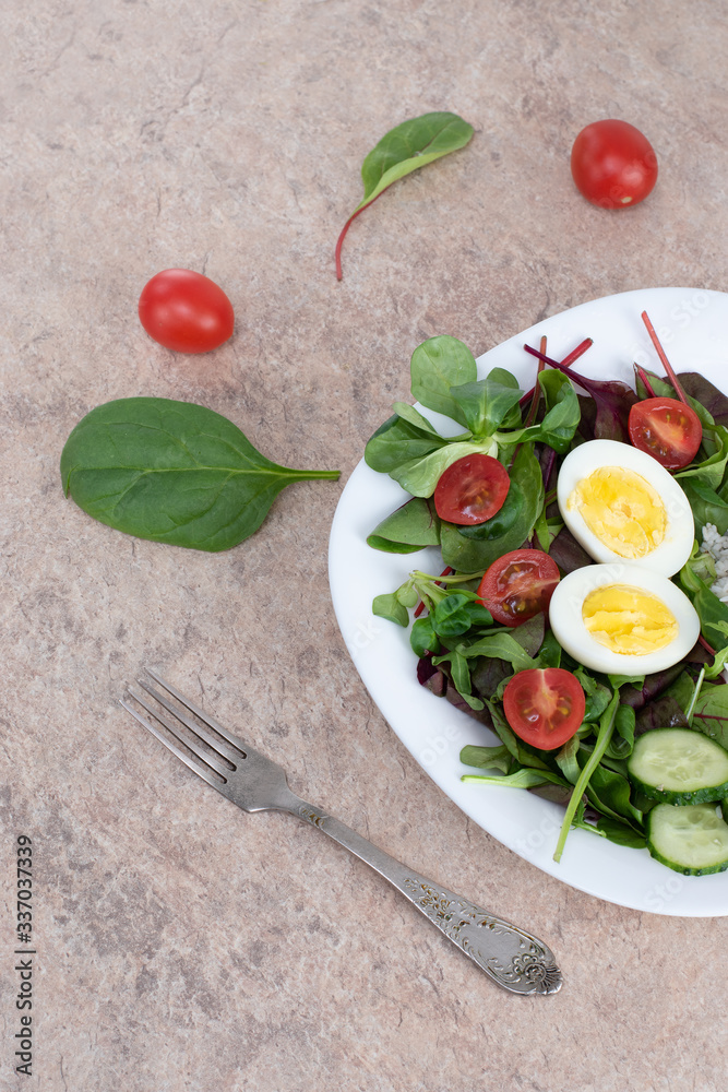 Salad of green vegetables, tomato and rice in a white plate. Rice with vegetables and eggs on a white plate. Salad of green vegetables, tomato and rice in a white plate. Rice with vegetables and eggs on a white plate.