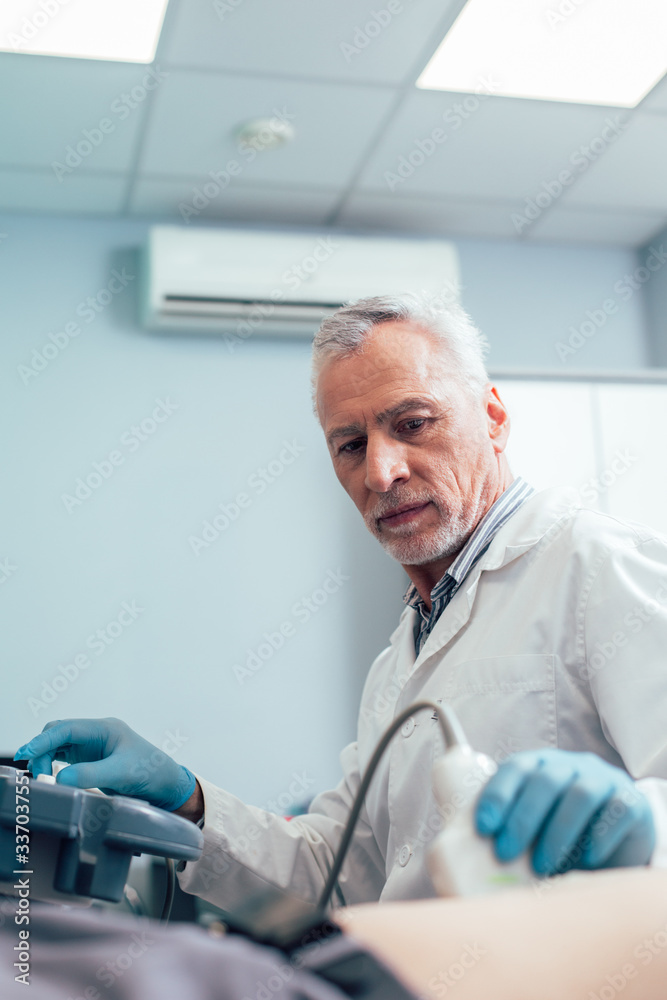 Doctor in clinic working with modern ultrasound equipment Doctor in clinic working with modern ultrasound equipment
