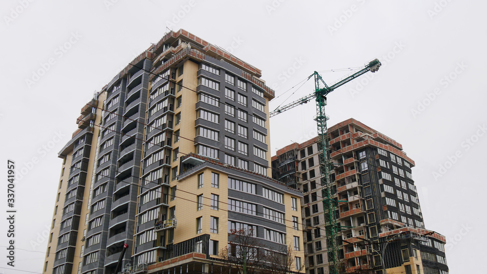 Fototapeta premium Construction site. High-rise multi-storey buildings under construction. Tower cranes near buildings.