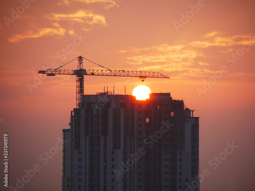 Construction site. Silhouette of a building under construction on sunset background. Silhouette of a building under construction against the backdrop of dawn. Industrial background.