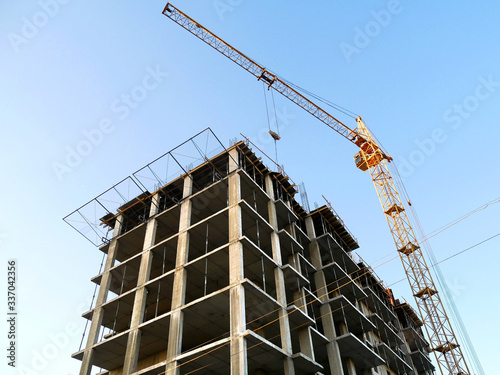 Self-erecting crane near the building under construction. Construction site background.