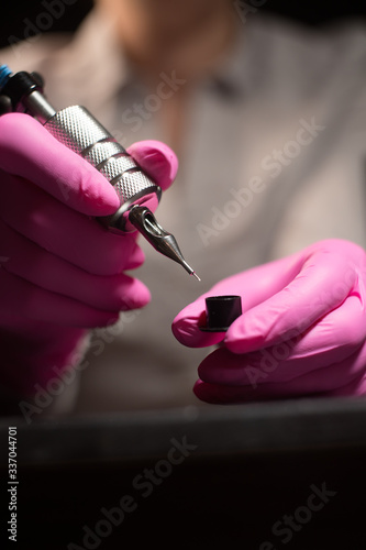 large female hands dunk paint tattoo machine