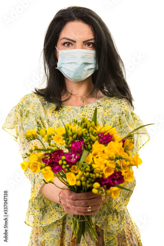 Woman with protective mask giving flowers photo