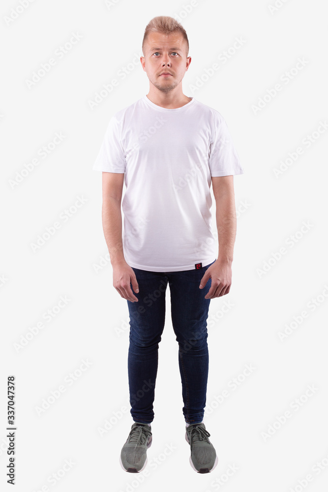 Man in casual wear stands straight, looks at camera. Full length Man in casual wear stands straight, looks at camera. Full length