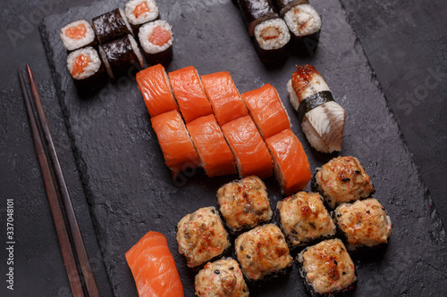 Sushi rolls on a black stone slatter