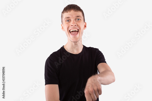 Young man laughing with wide opened mouth, looking at camera. Human emotions