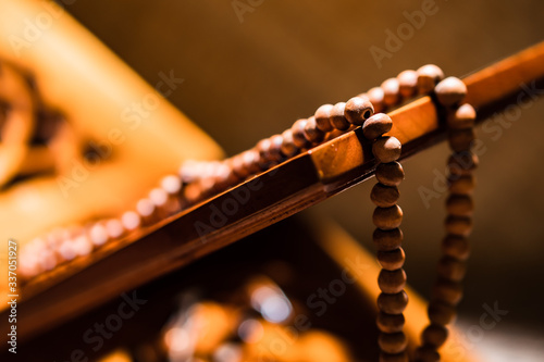 Islamic prayer beads or tasbih on rihal or quran book stand made from carved wood. It is suitable for background of Ramadan-themed design concepts or other Islamic religious events. photo
