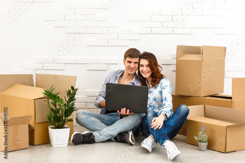 Smiling couple leaning on boxes in new home